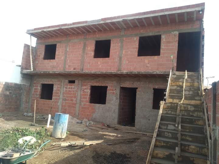Edificação de dois andares em tijolo vermelho com laje